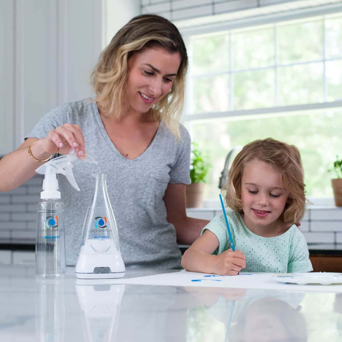 Force of Nature being made in the kitchen by a woman with her child next to her. Showing that this cleaner is non-toxic and can be used around children.