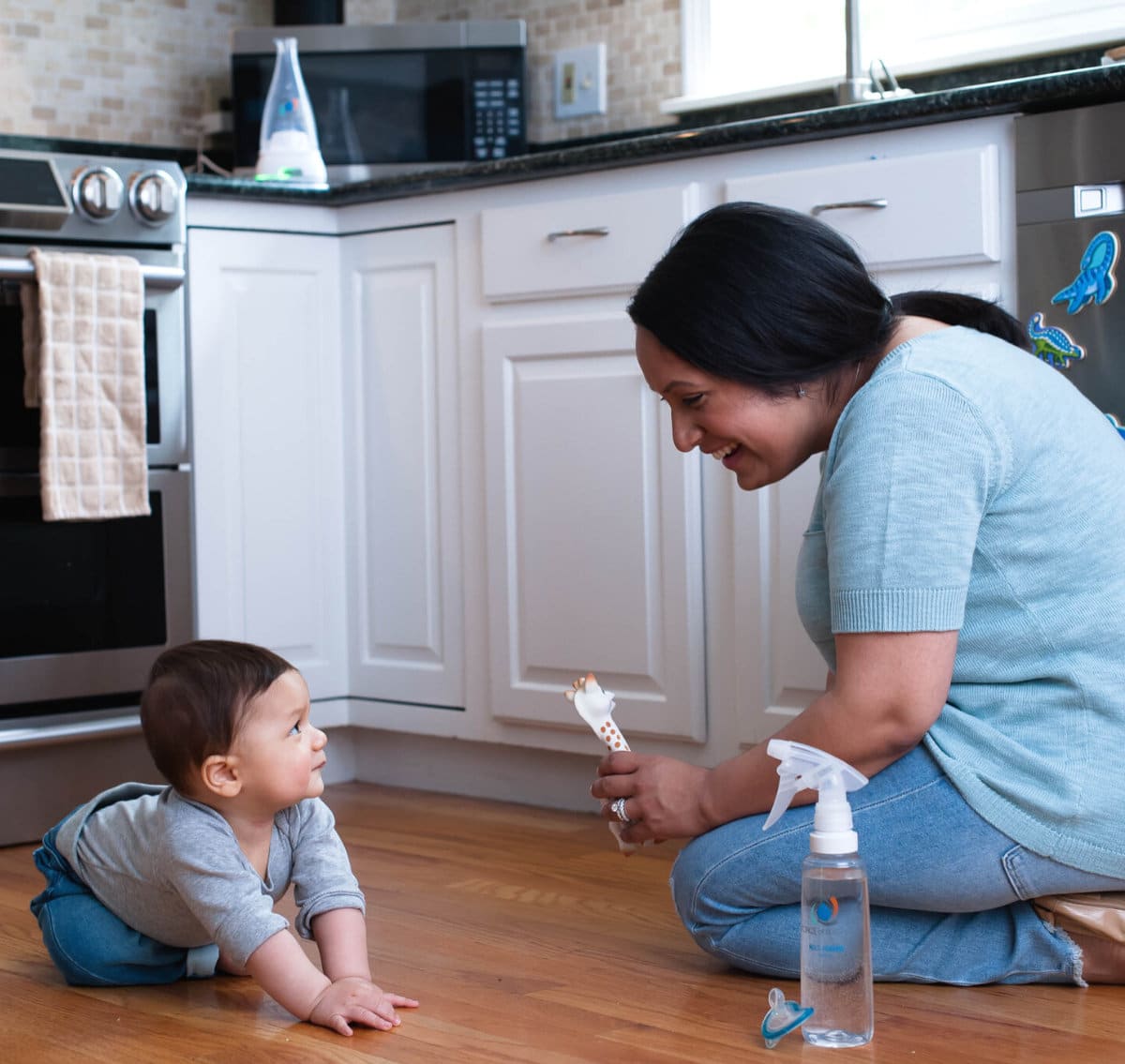 adult and a child on a kitchen floor where there is Force of Nature cleaner